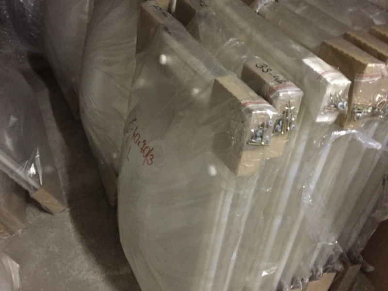 Folienverpackte Kuppelschalen mit Kantenschutz aus Pappe im Lager, an den Kanten T&uuml;ten mit Schrauben, handschriftlich beschriftet.