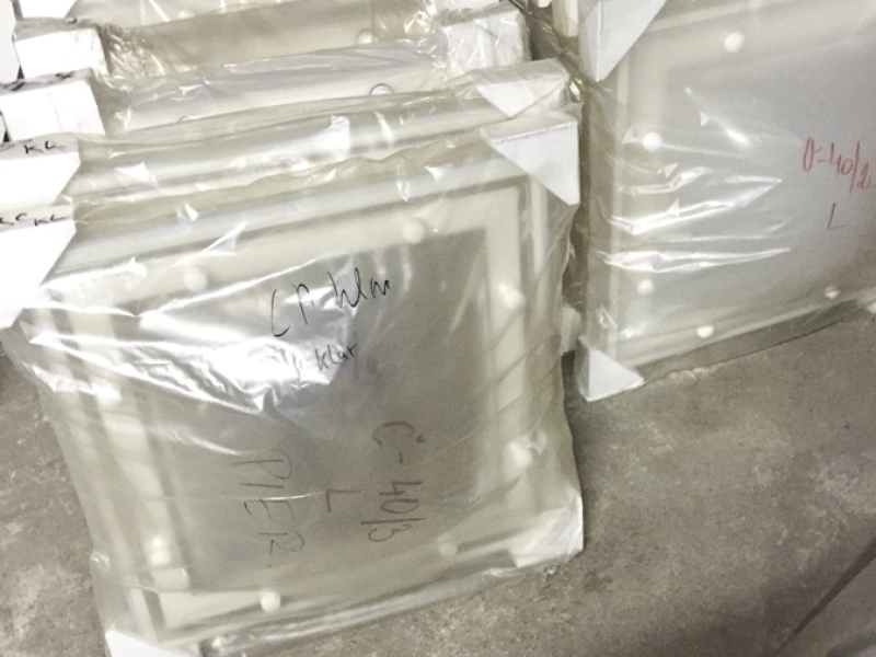 Zwei Stapel folienverpackter klarer Kuppelschalen mit Eckschutz, handschriftlich mit Ma&szlig;en beschriftet.