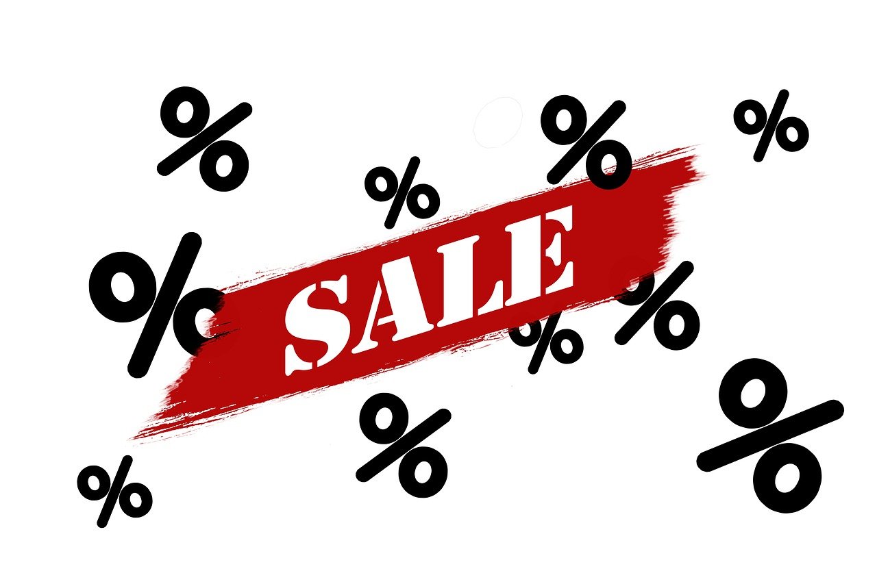 Grafik: der Schriftzug „Sale“ auf einem roten Pinselstrich, umgeben von schwarzen Prozentzeichen.