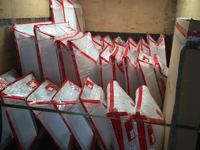 Beladener Lkw-Innenraum mit vielen rot-wei&szlig; verpackten Lichtkuppeln, hochkant gestellt und verzurrt.